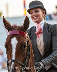 A practiced smile covers the seriousness of this equestrian competition.