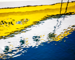 A boat's portholes shimmer in the blue July waters of Green Bay.